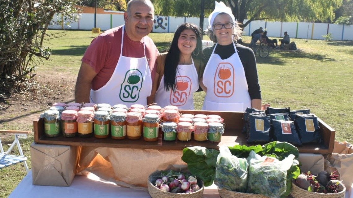 El equipo de Sabores & Colores en su puesto, con frascos, verduras y bolsas de bocashi