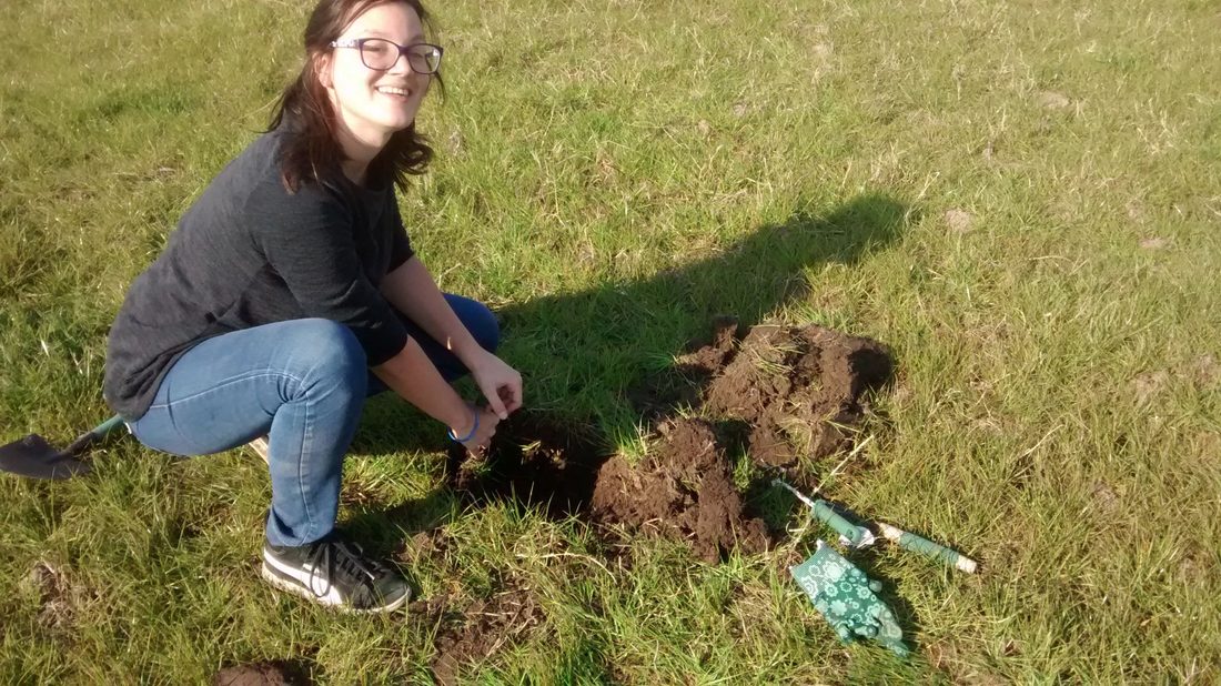 Una integrante del equipo trabaja la tierra de la huerta